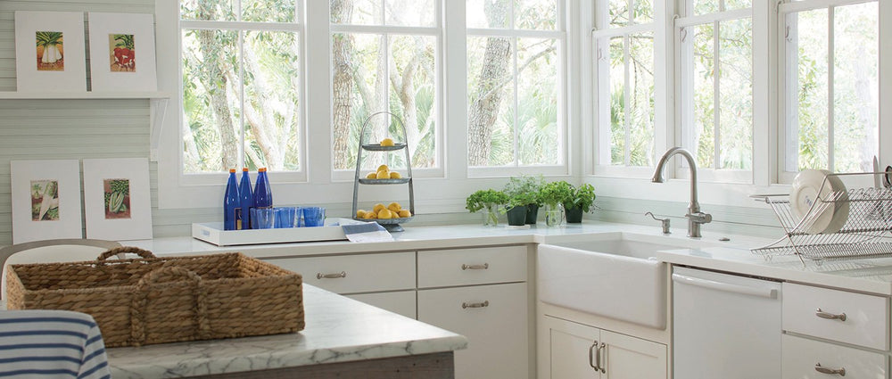white kitchen with white cupboards, large windows and shiplap panelling 
